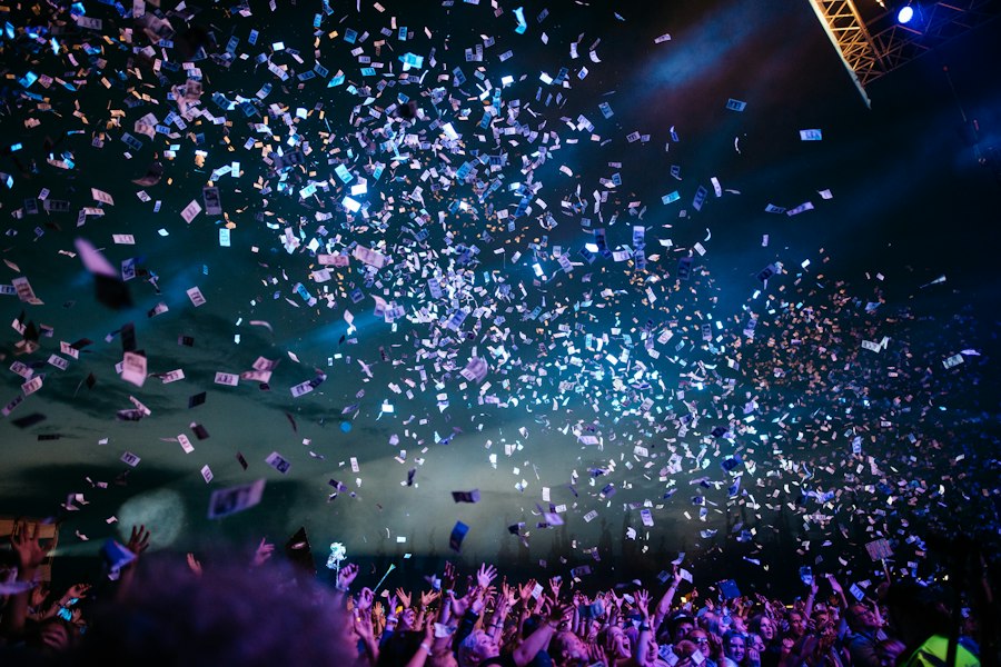 A crowd at a concert with their hands in the air